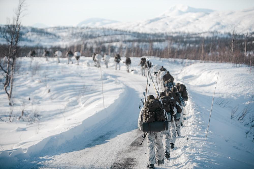 U.S. Marines with Marine Rotational Force Europe hike through winter terrain in Blatind, Norway.